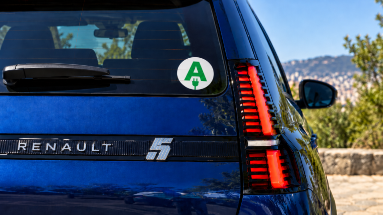 Arrière d'une Renault 5 électrique bleue avec un disque « A » d'apprenti conducteur orné d'une prise électrique
